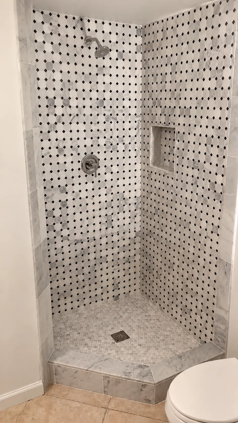 Corner shower with marble octagon mosaic, niche and marble threshold